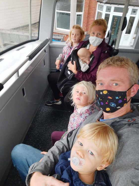 Family with 4 children sat upstairs on a double-decker bus