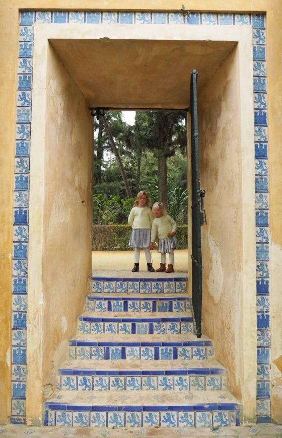 2 small girls stood on some decoratively tiled steps