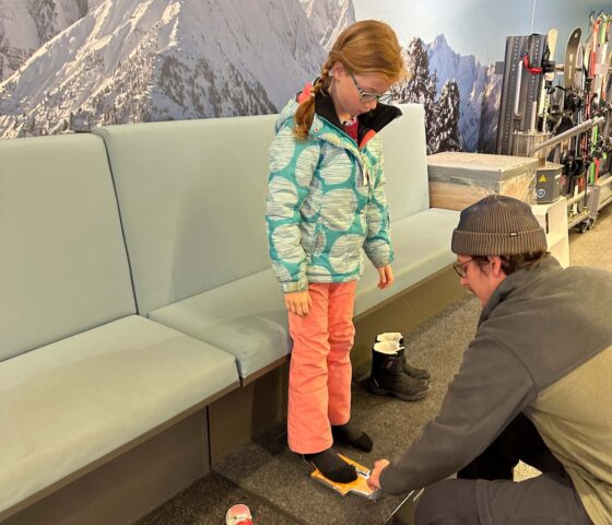 Girl getting her feet measured in a ski hire shop