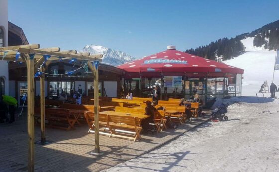 Outdoor seating area at a mountain restaurant in a ski resort