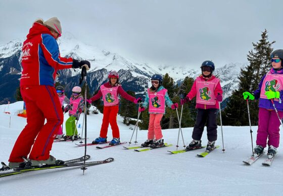 Group of children having a ski lesson in the mountains