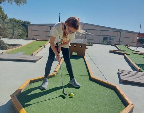 Girl playing mini golf on an outdoor course