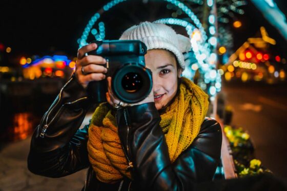 Lady taking a photo at night with an SLR camera