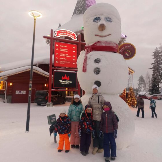 Family stood in front of a giant snowman at the Santa Claus Holiday Village