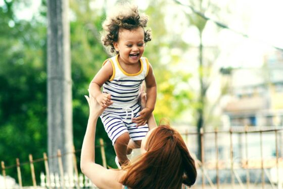 Mother lifting a smiling child in the air