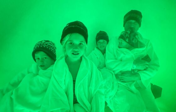 Family wearing dressing gowns and wooly hats and illuminated green