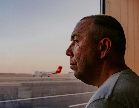 Man looking concerned looking out onto an airport runway