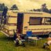 2 small children sat in small chairs in front of a classic brown and beige Hymer motorhome